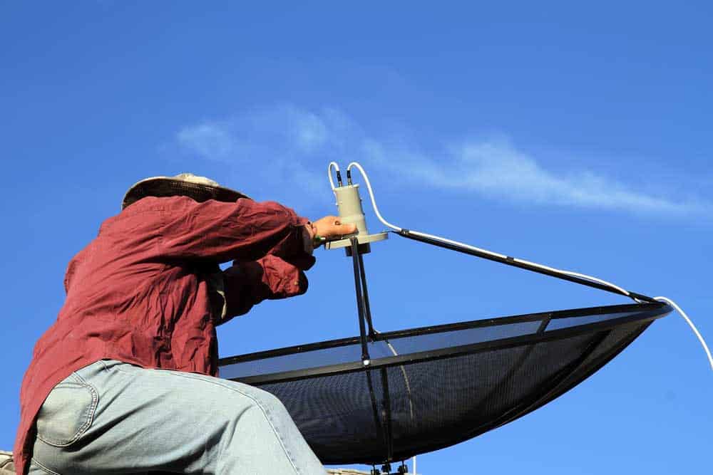 Skilled technician installing satellite receiver 