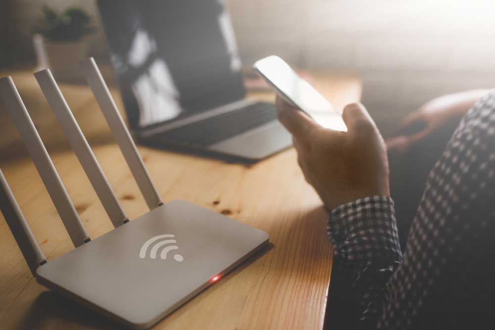 Starlink Installation: A closeup of a wireless router and a man using a smartphone