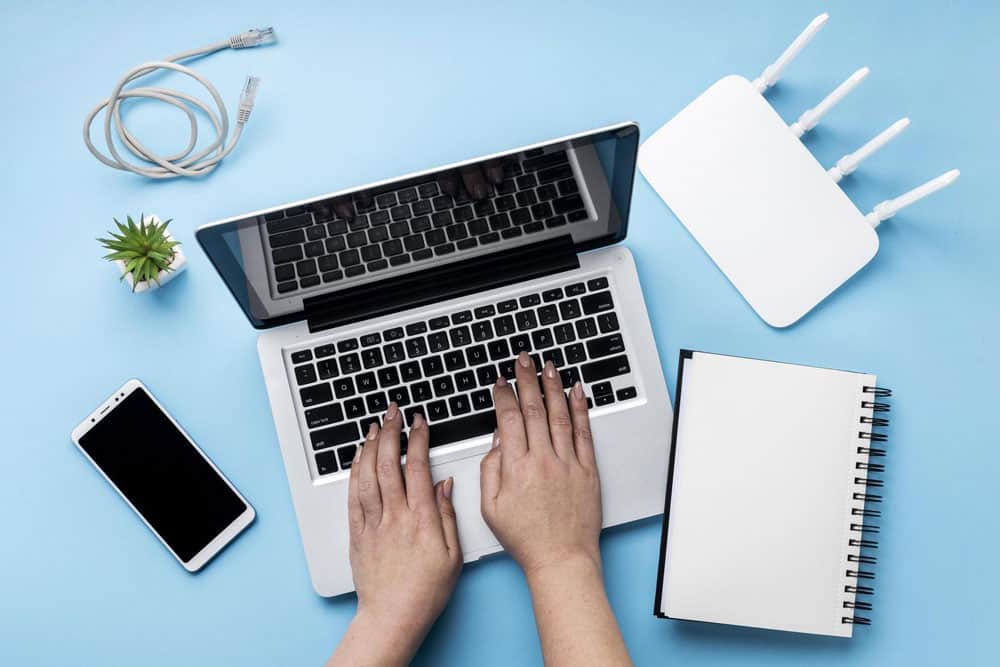 top view wi-fi router with hands using laptop smartphone