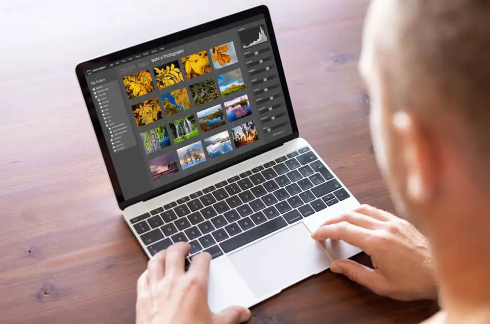 A man editing photos using a desktop app on a laptop