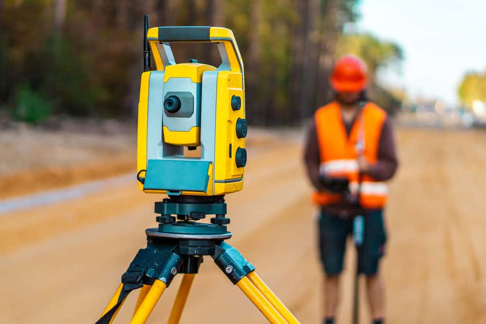 A surveyor engineer with a theodolite on a road construction site