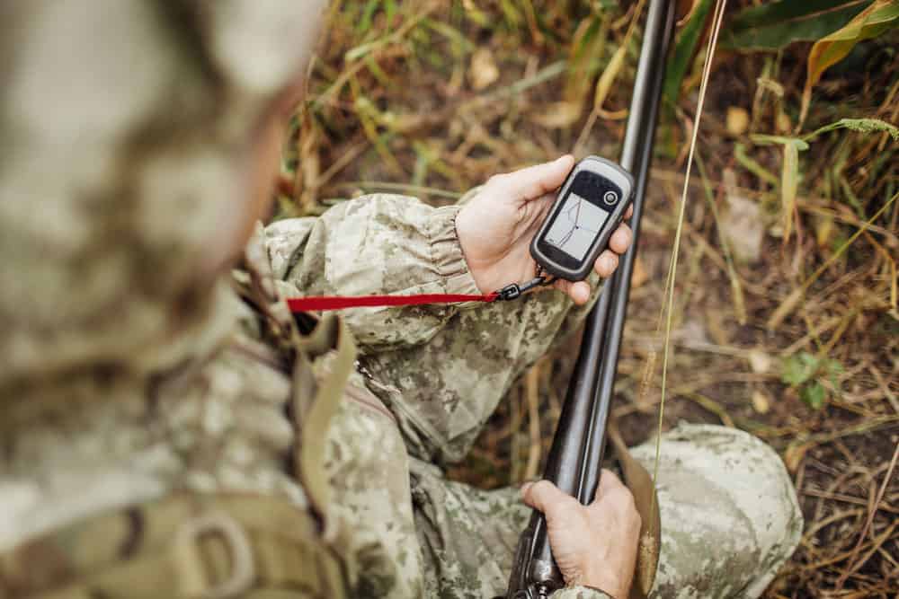 An adult hunter determines the route on the GPS navigator