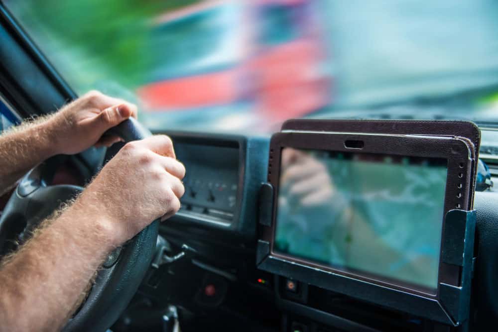 A truck driver holding a mobile phone GPS application