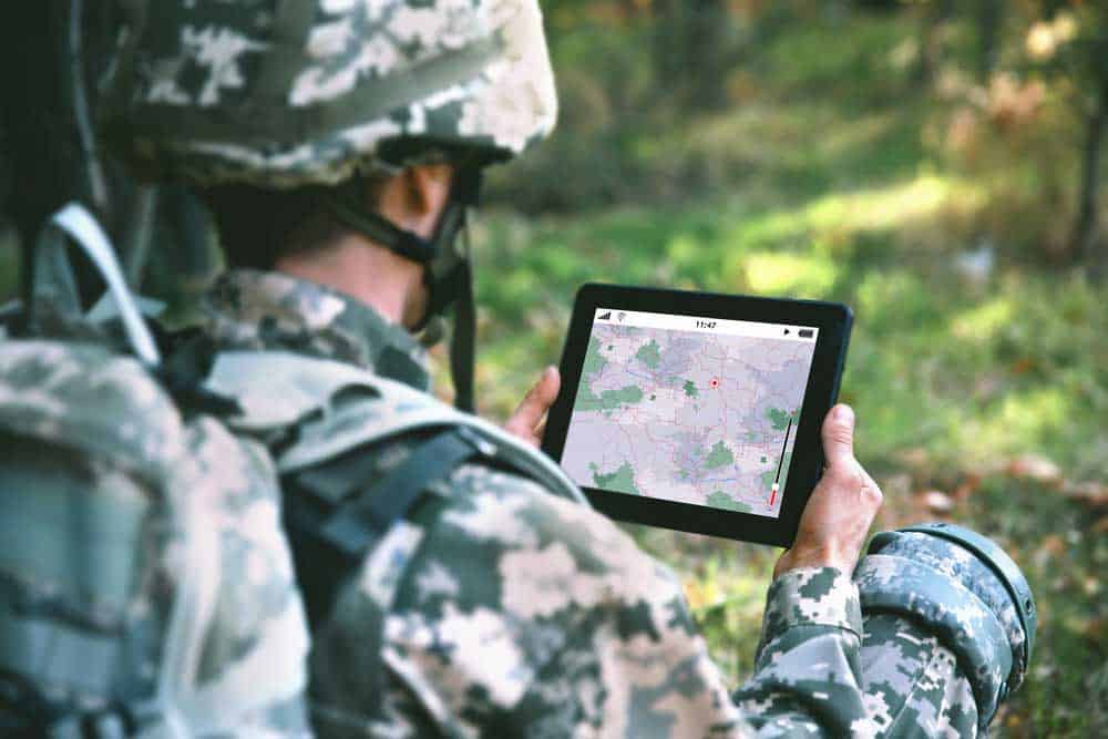 A soldier using a tablet with a map and GPS for navigation