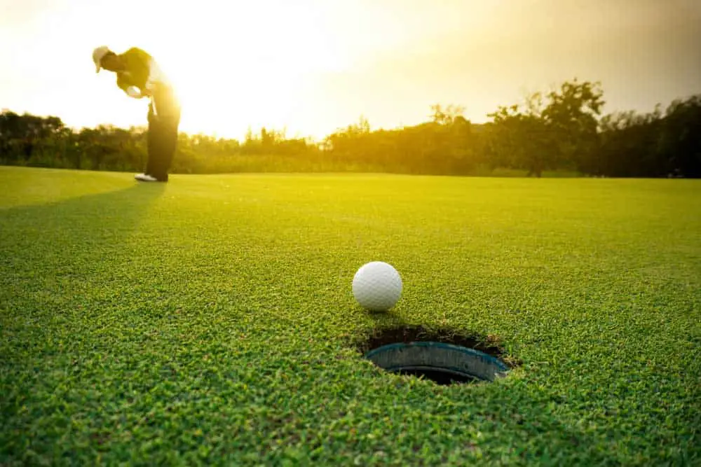 A united states golfer putting a golf ball on the green golf