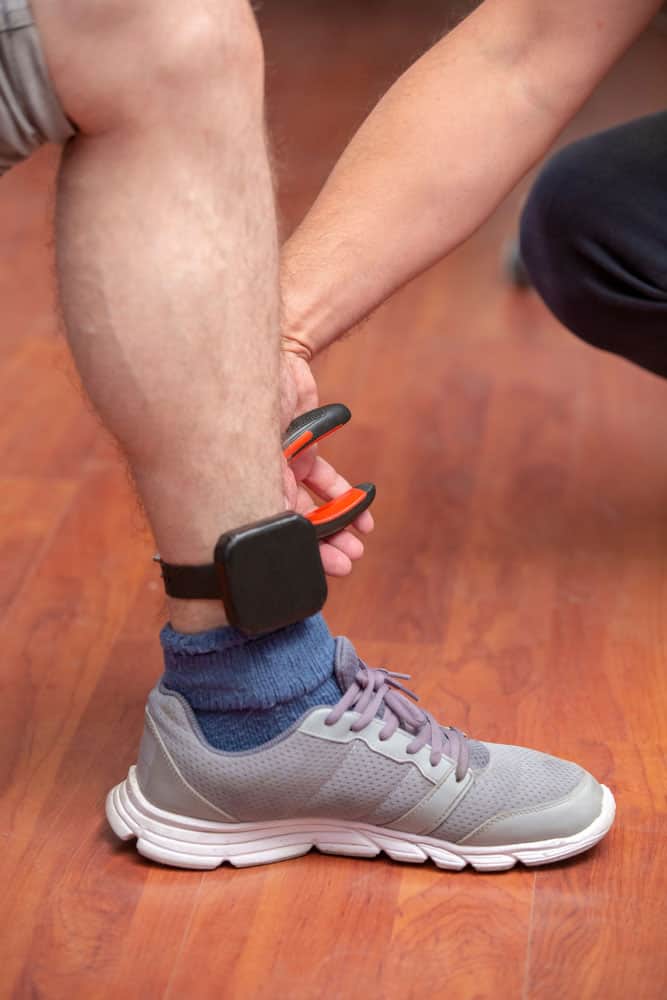 A person wearing an ankle monitor