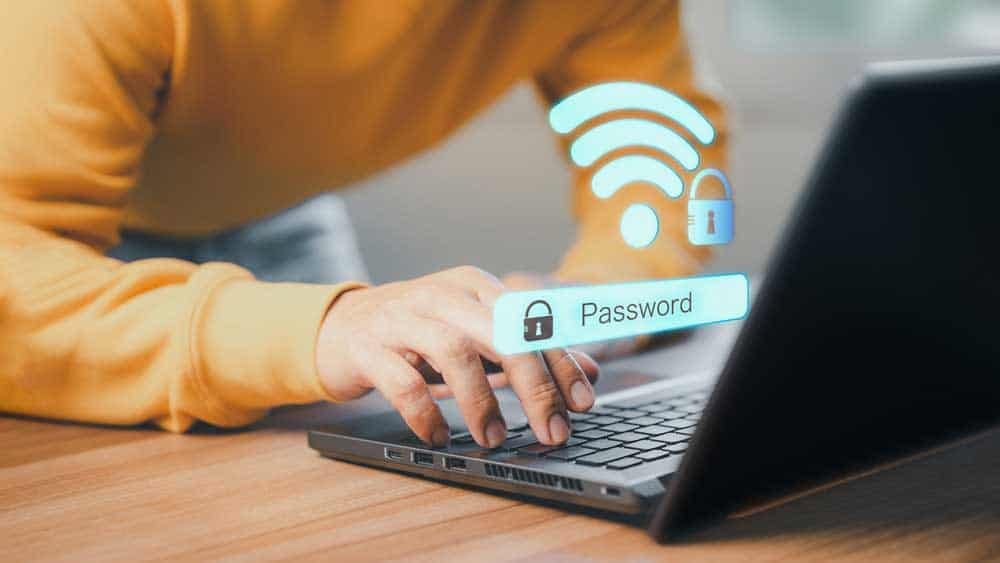 How To Reduce Home Internet Data Usage: A person connecting a computer to a secure Wi-Fi network