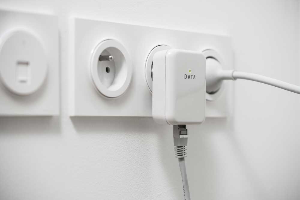 A powerline adapter is plugged into a wall socket.