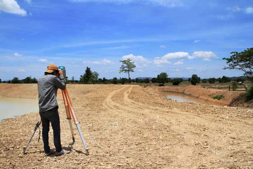 A land surveyor with his equipment at work