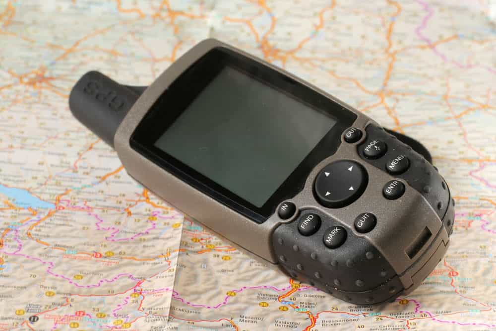 A GPS handheld device placed onto a paper map