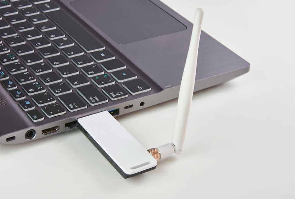 A USB modem with an antenna plugged into a laptop