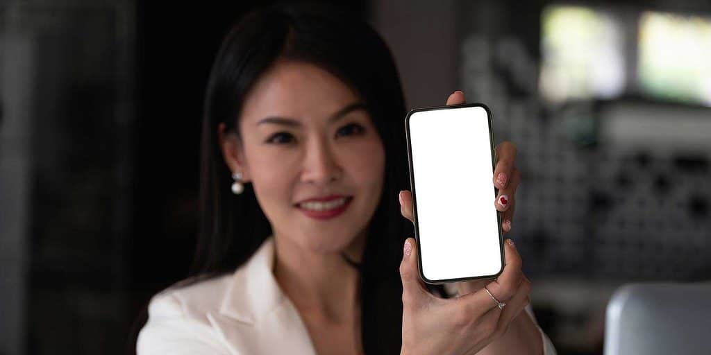 Businesswoman showing blank smartphone screen.