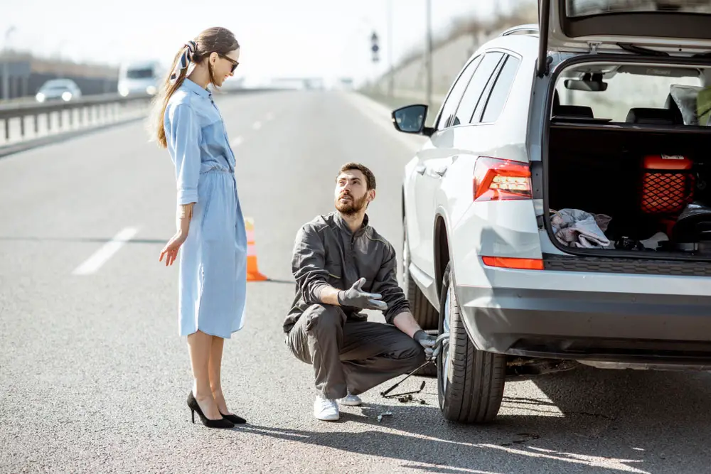 Young man changing car wheel