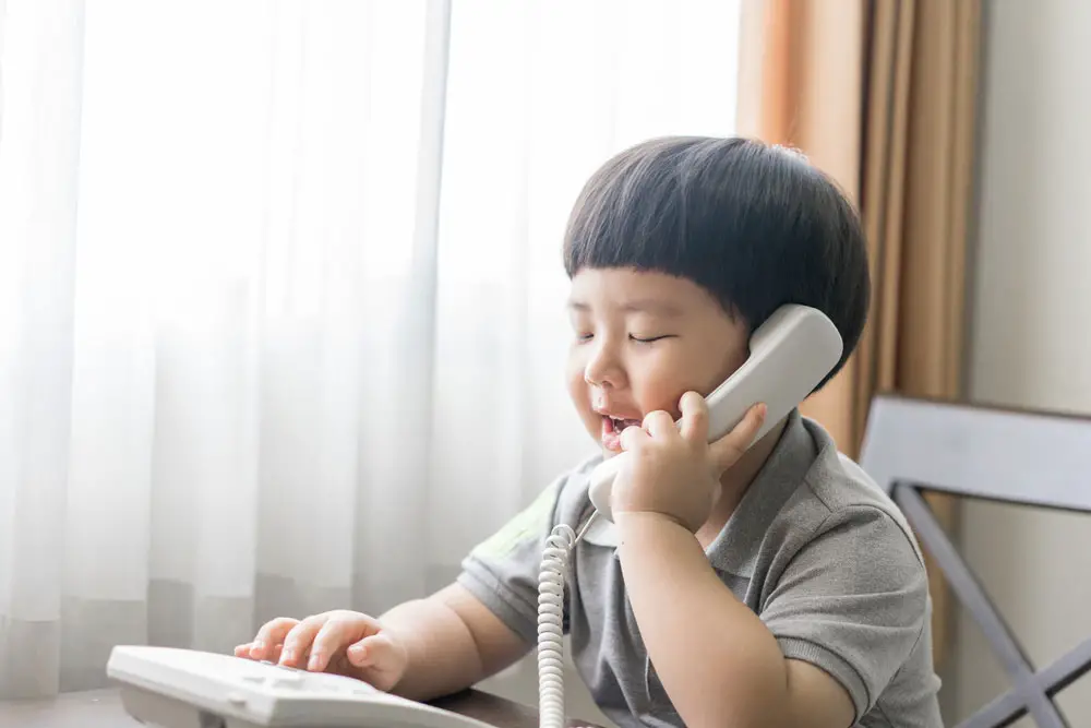 A kid making a call. 