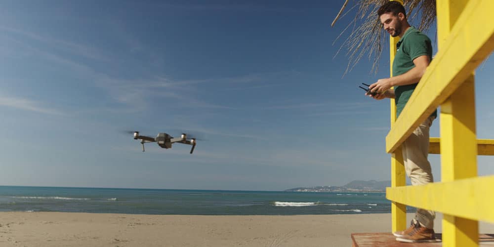 Man operating drone by the sea