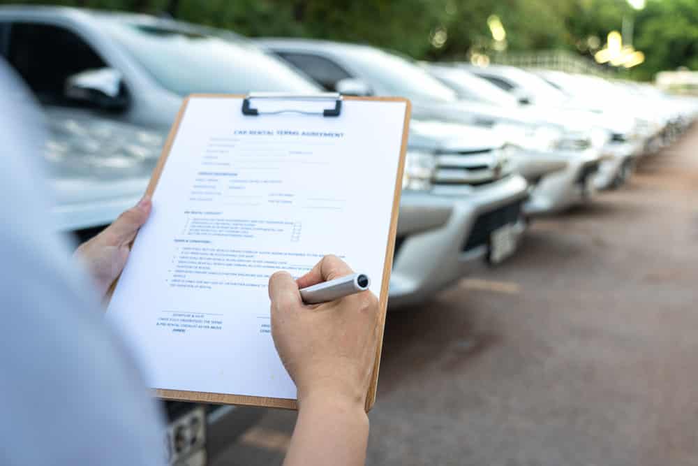 A customer signing on the agreement terms of car rental service