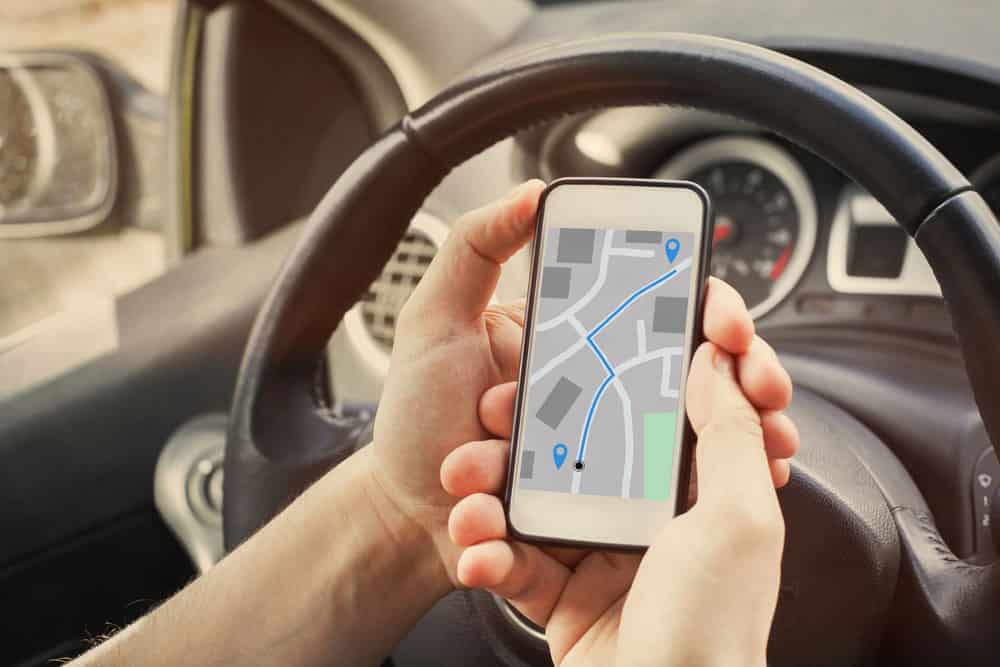 Driver using direction navigation on GPS map on the screen of a mobile smartphone