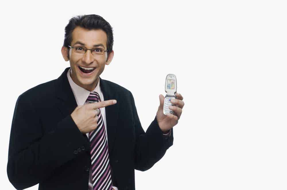 A businessman pointing at a flip phone