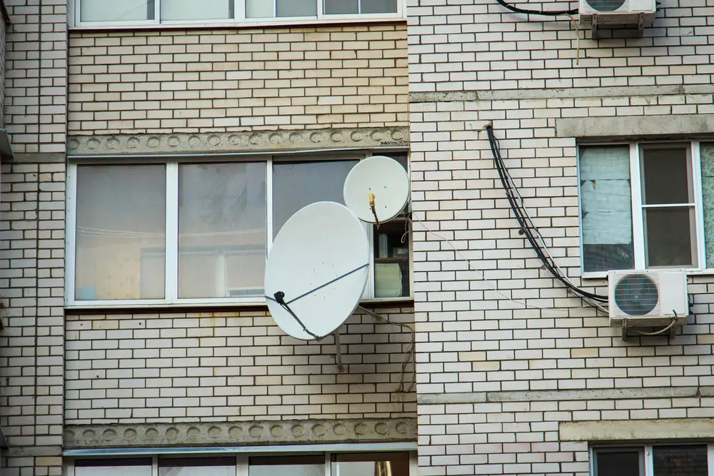Two satellite TV antennas mounted on a wall