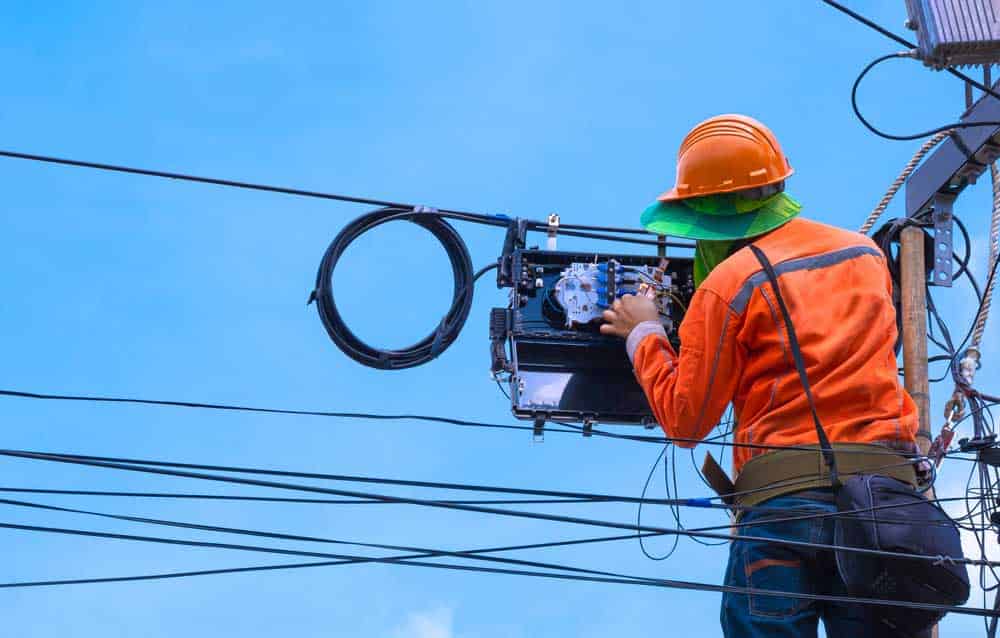 A technician checking code numbers on fiber optic cable lines