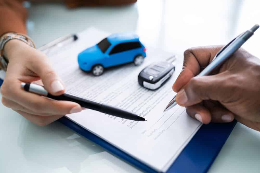 Can Repo Track Your Car GPS: A person signing a car loan agreement contract