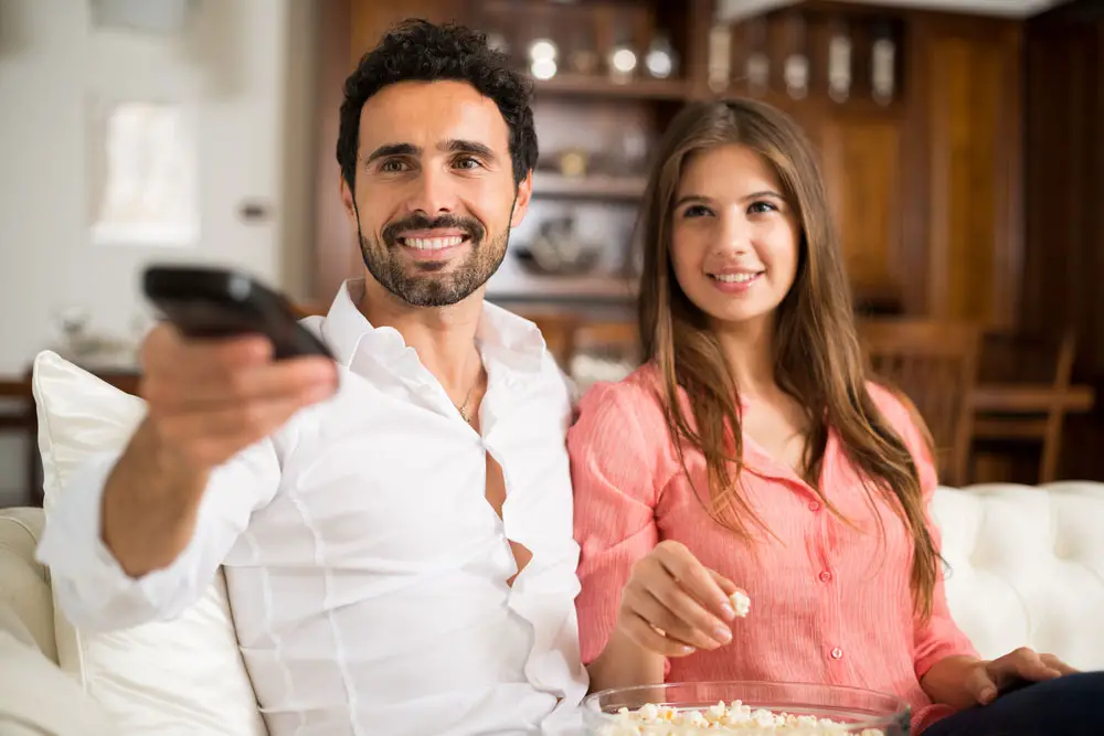 A young couple watches TV. 