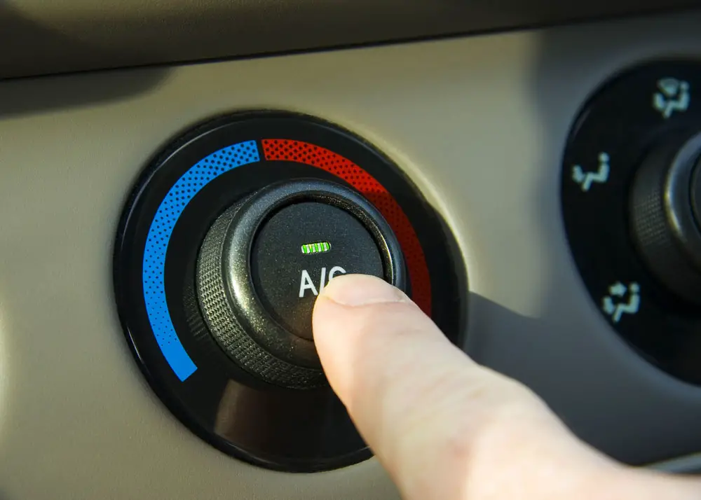A car’s AC button with the setting turned on