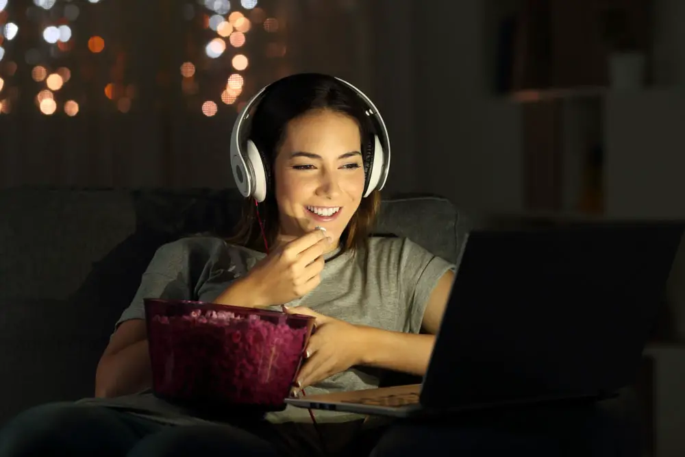 A woman watching a movie with a streaming device