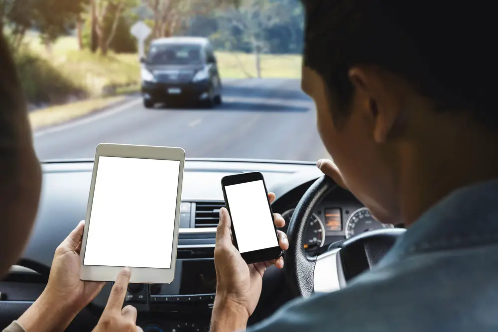 A couple using a phone inside the car