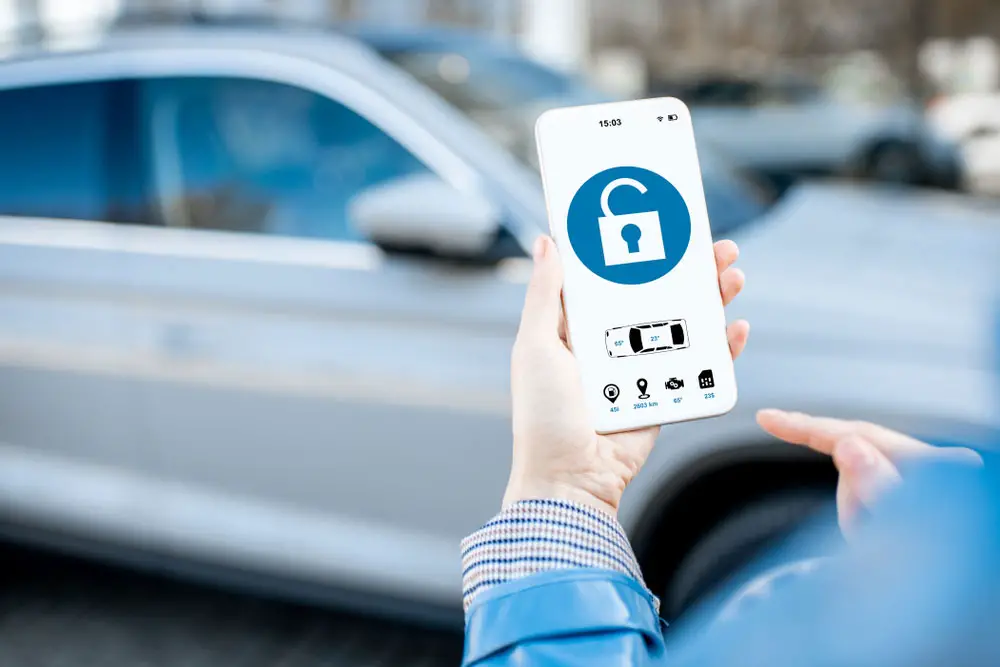 A person using a remote lock/unlock feature to access a car using a smartphone app