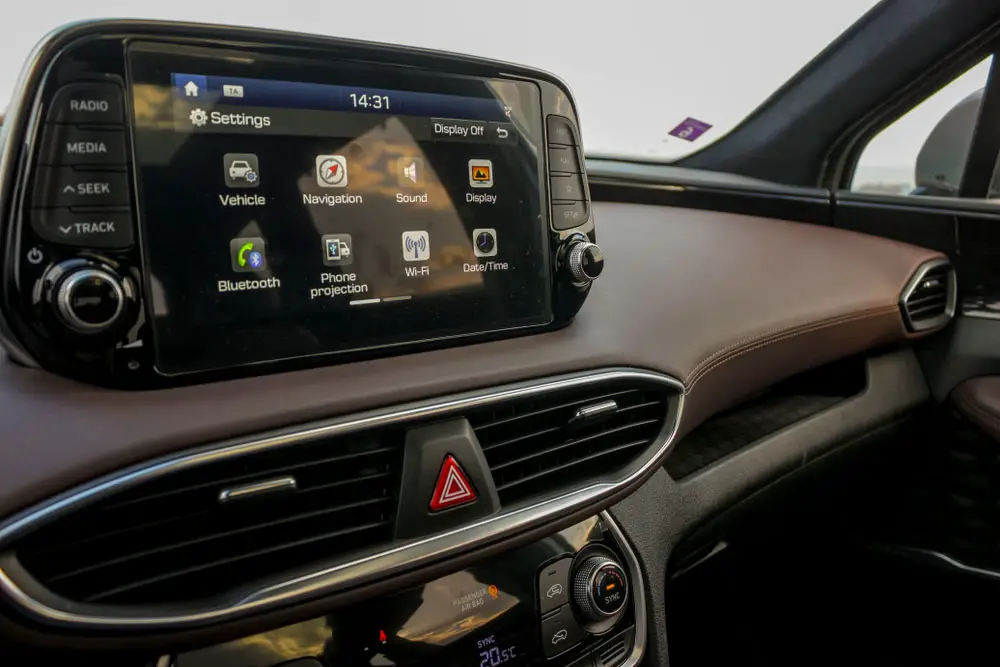 A car infotainment system with multiple features like Bluetooth, navigation, vehicle settings, and phone projection