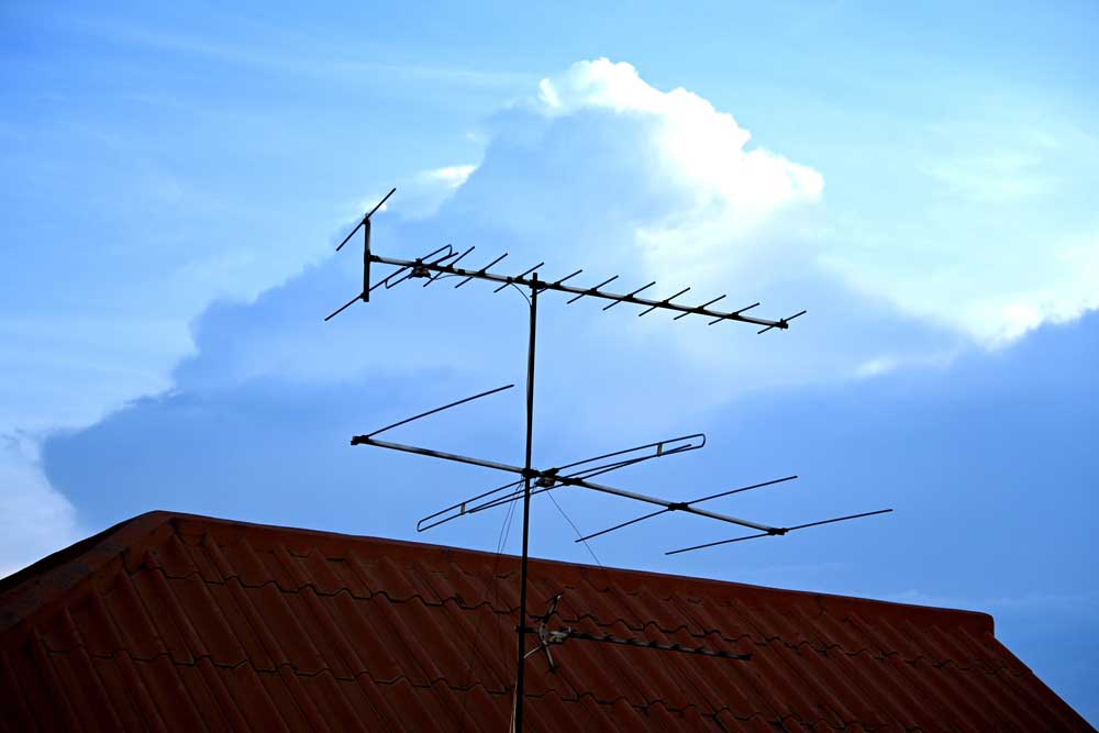 A photo of a television antenna over a roof