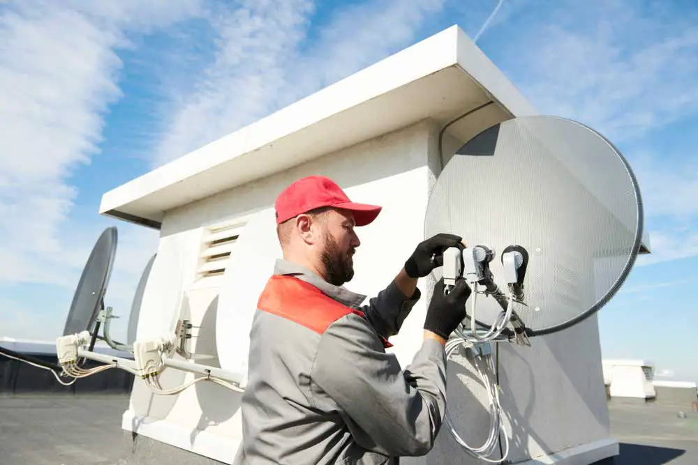 A service installer working on an antenna