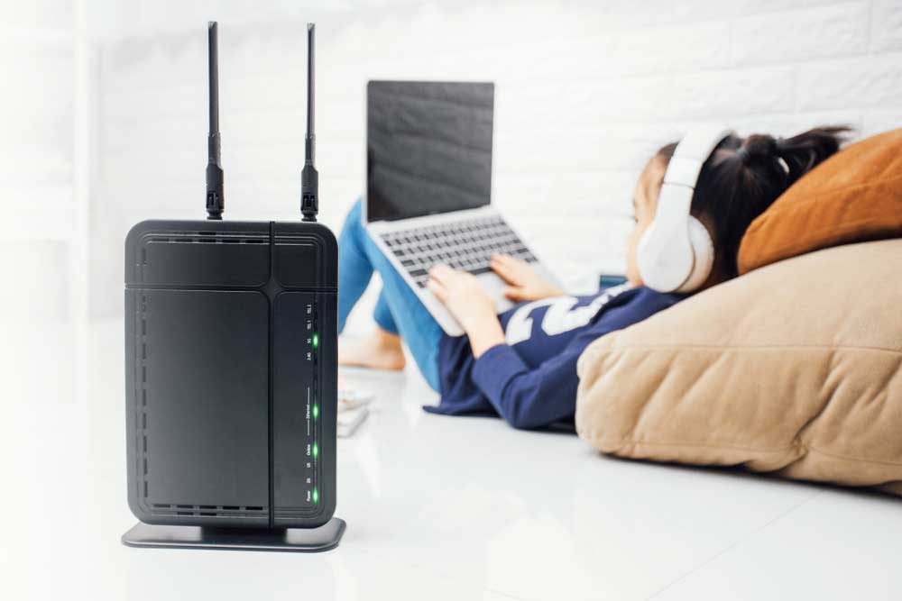 A wireless router with kids using a laptop at home
