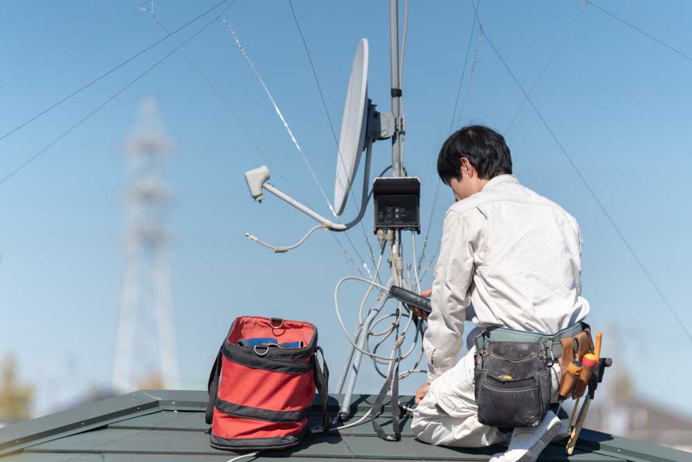 A professional installing an antenna on the rooftop